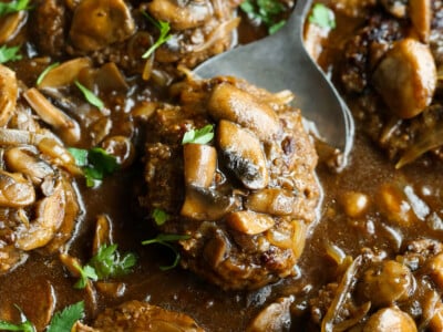 Easy Salisbury Steak recipe in a skillet with brown gravy, onions and mushrooms