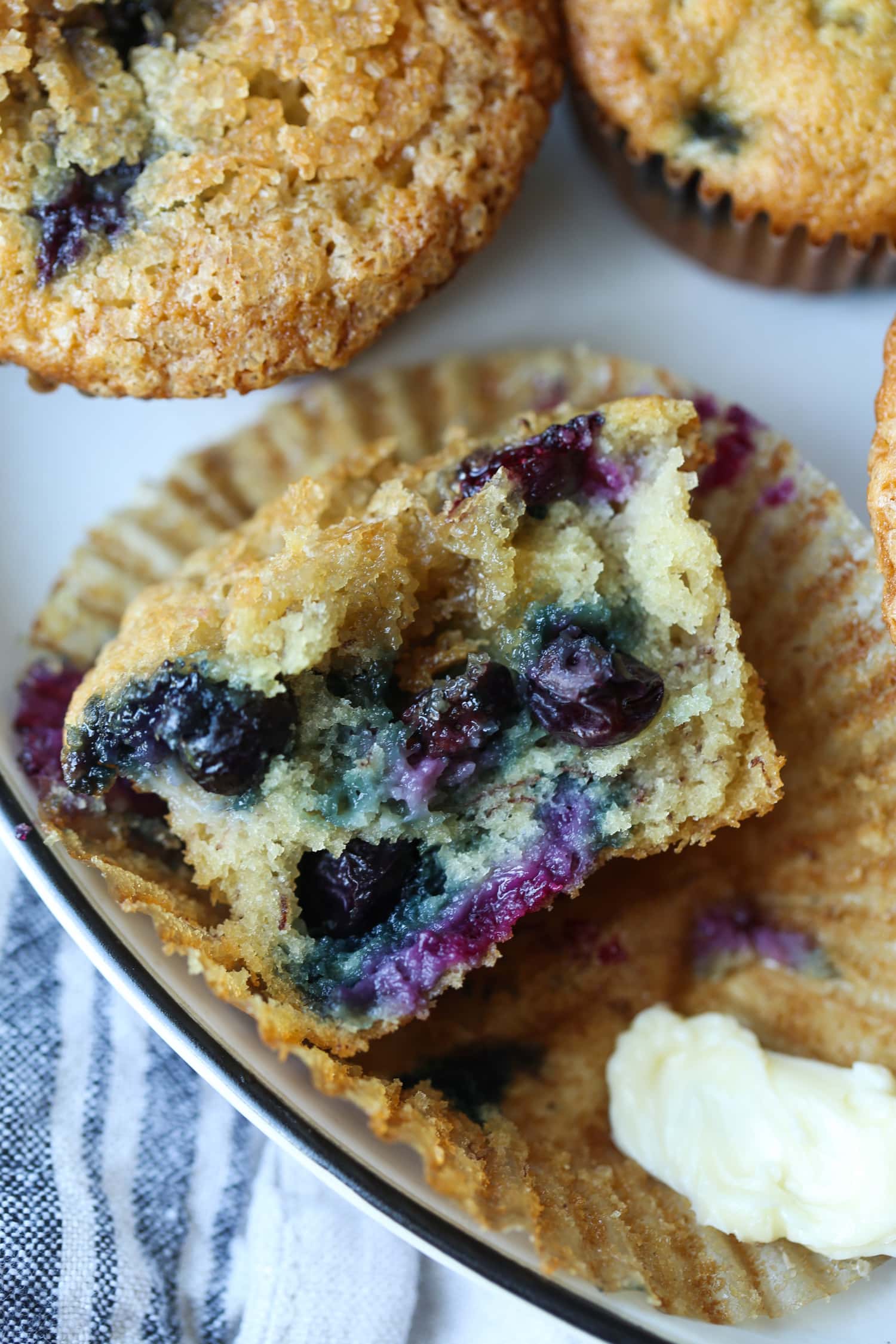 Half of a muffin with fresh blueberries in it.