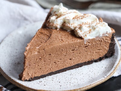 A slice of Nutella cheesecake with whipped cream.