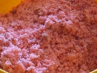 A close-up shot of the crumbled strawberry cake in a yellow bowl
