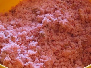 A close-up shot of the crumbled strawberry cake in a yellow bowl