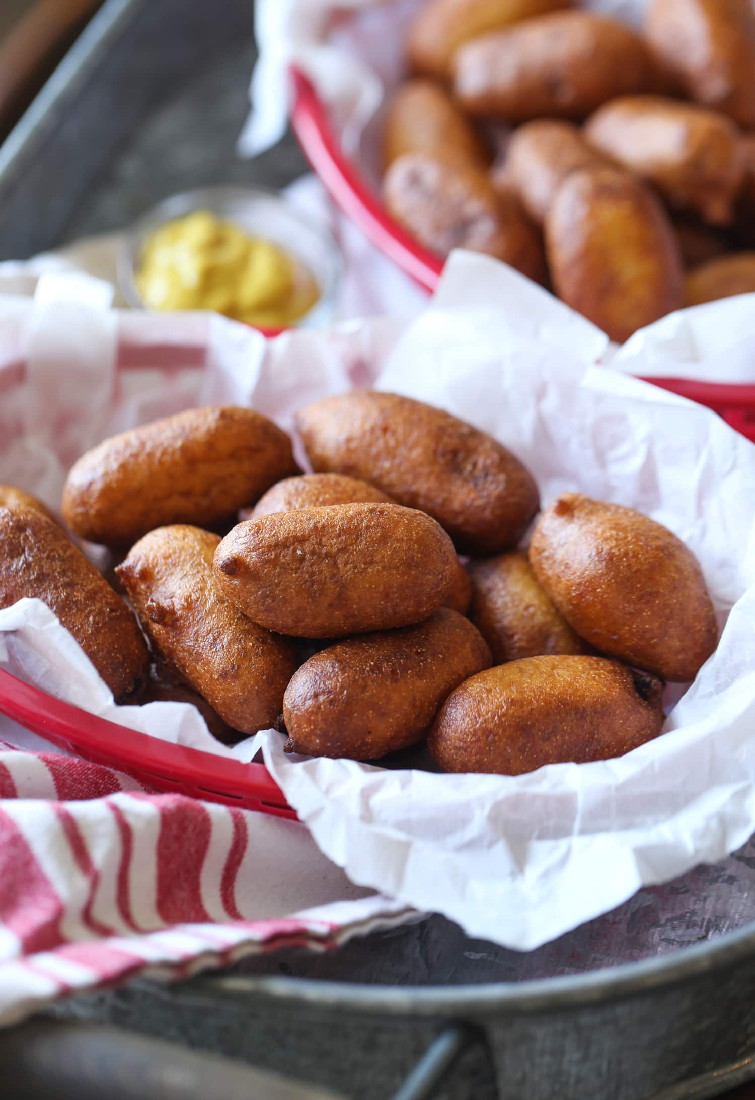 A basket of mini hot dogs fried in cornmeal batter.