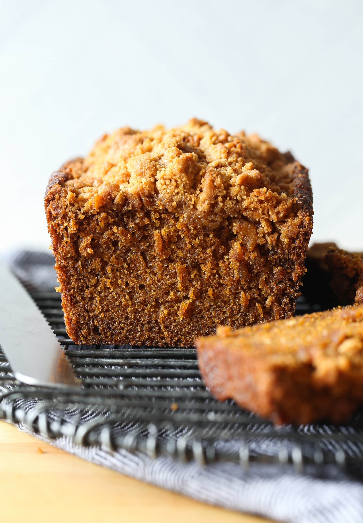 Loaf of pumpkin bread cut on a cooling rack