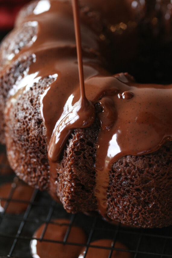pouring ganache on a chocolate bundt cake