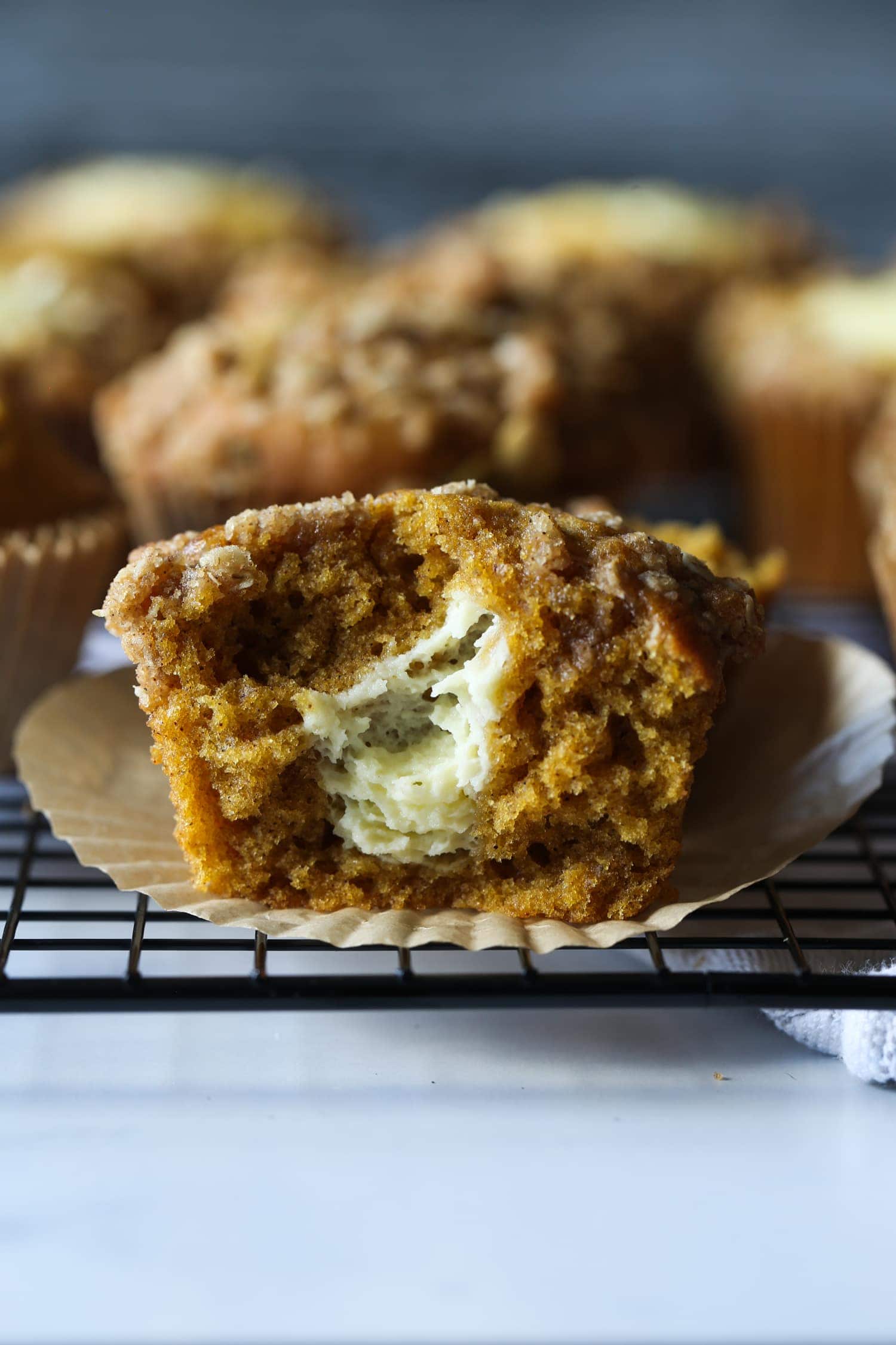 Pumpkin muffin broken in half with cream cheese filling