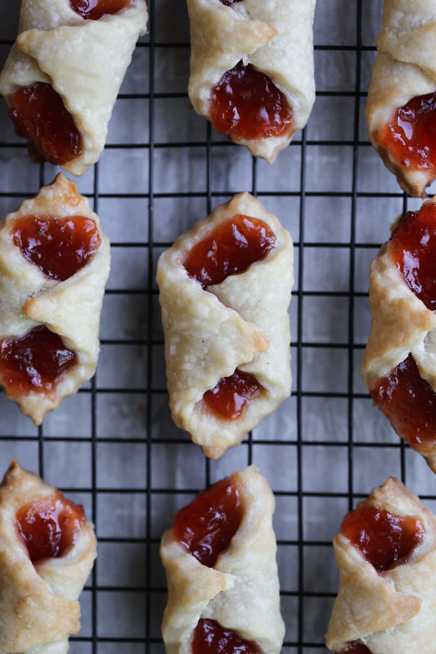 Rows of baked kolaczki filled with strawberry preserves.