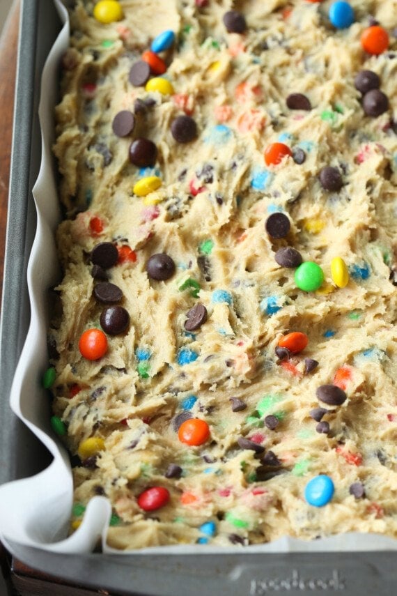 M&M cookie dough pressed into a 9x13 pan