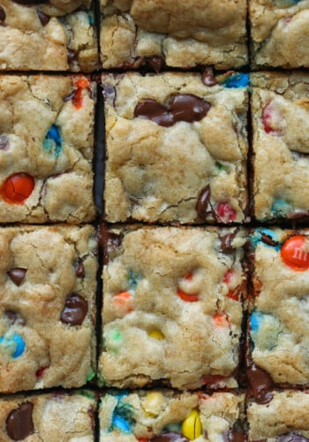 M&M Cookie Bars cut into squares on a cutting board from overhead