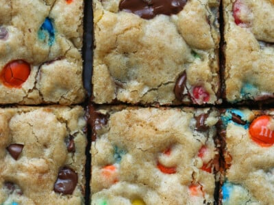 M&M Cookie Bars cut into squares on a cutting board from overhead