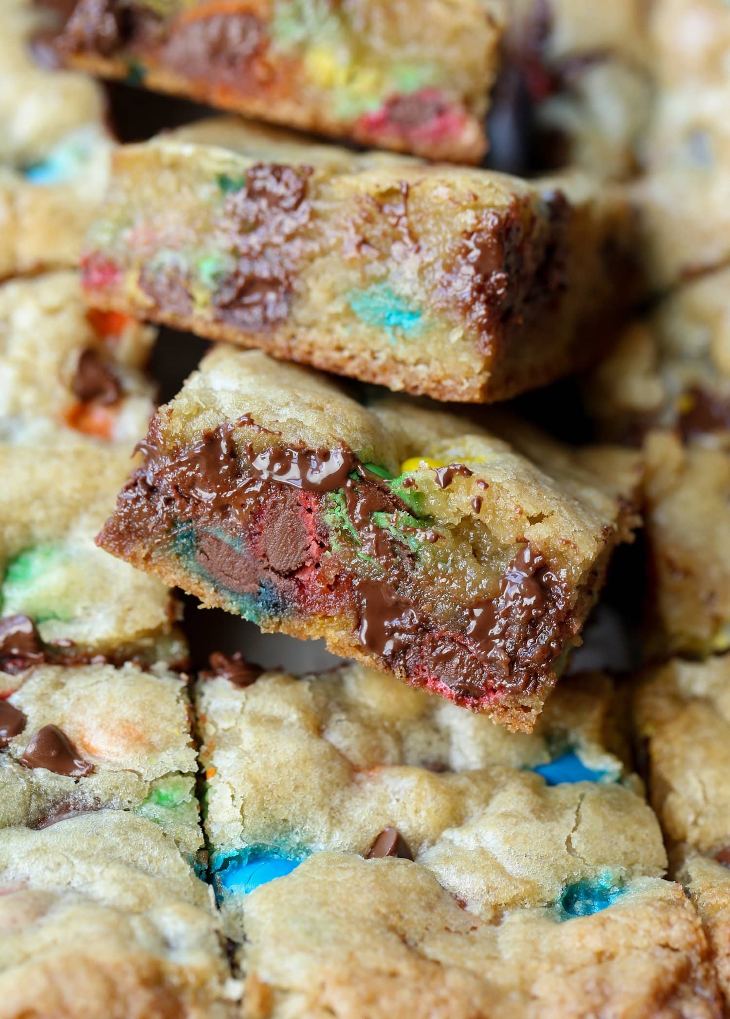 The inside of a M&M cookie bar cut with melted chocolate