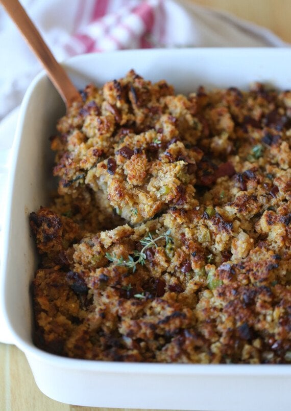 Cornbread stuffing in a casserole dish with a scoop