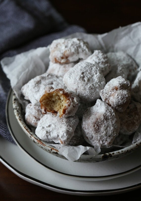 Rice fritters coated in powdered sugar in a bowl