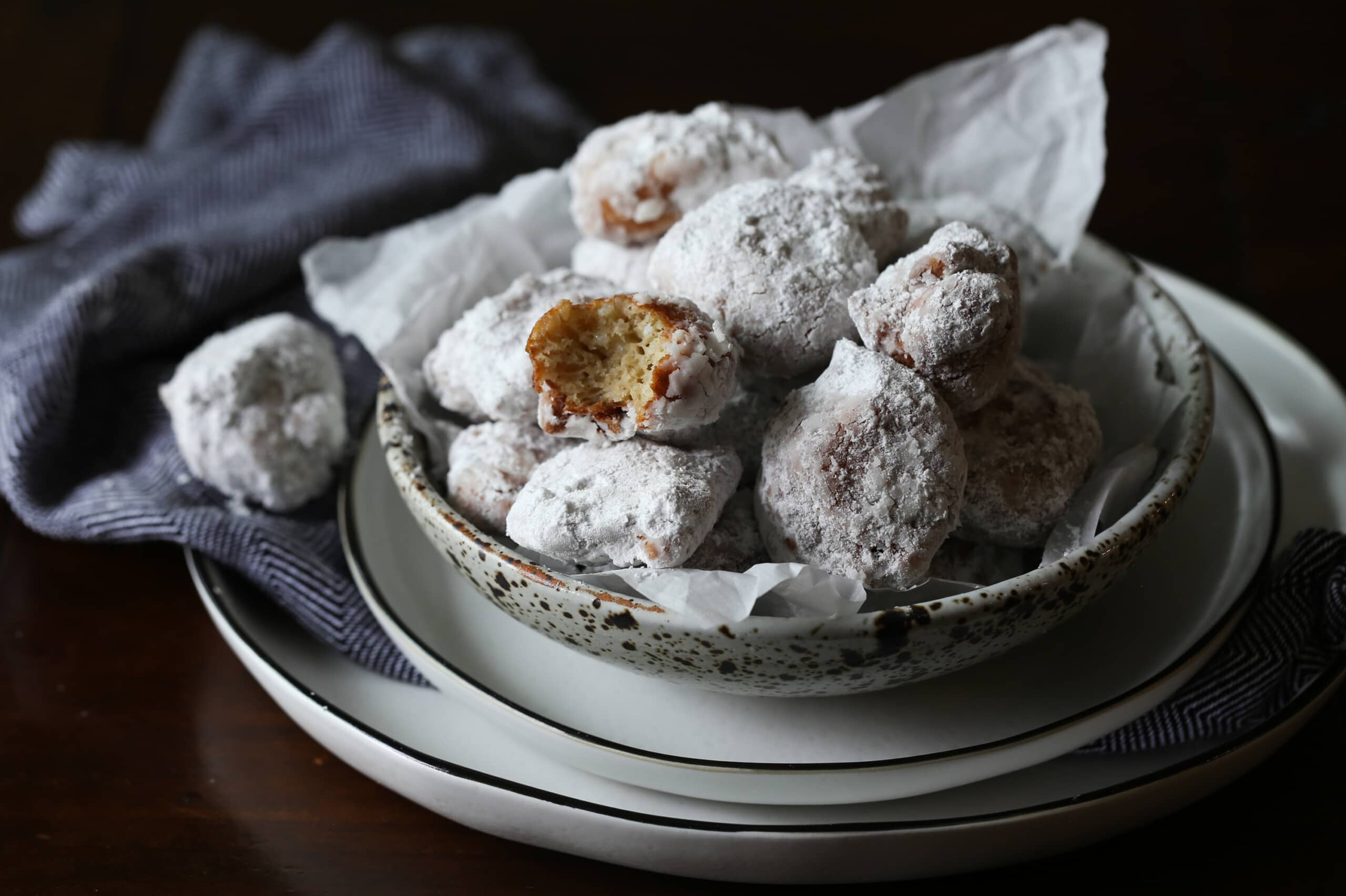 Bowl filled with powdered sugar coated rice fritters