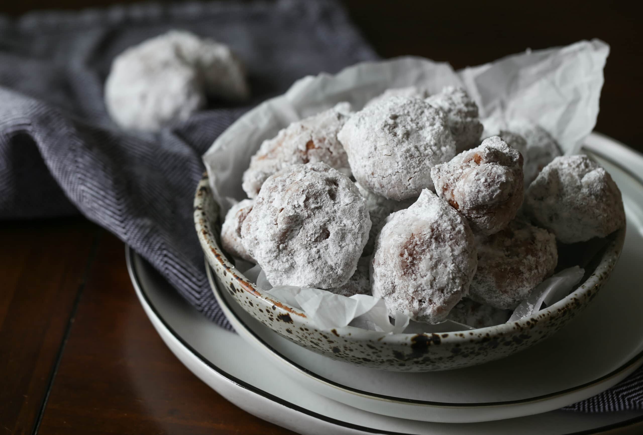 donuts coated in powdered sugar in a bowl