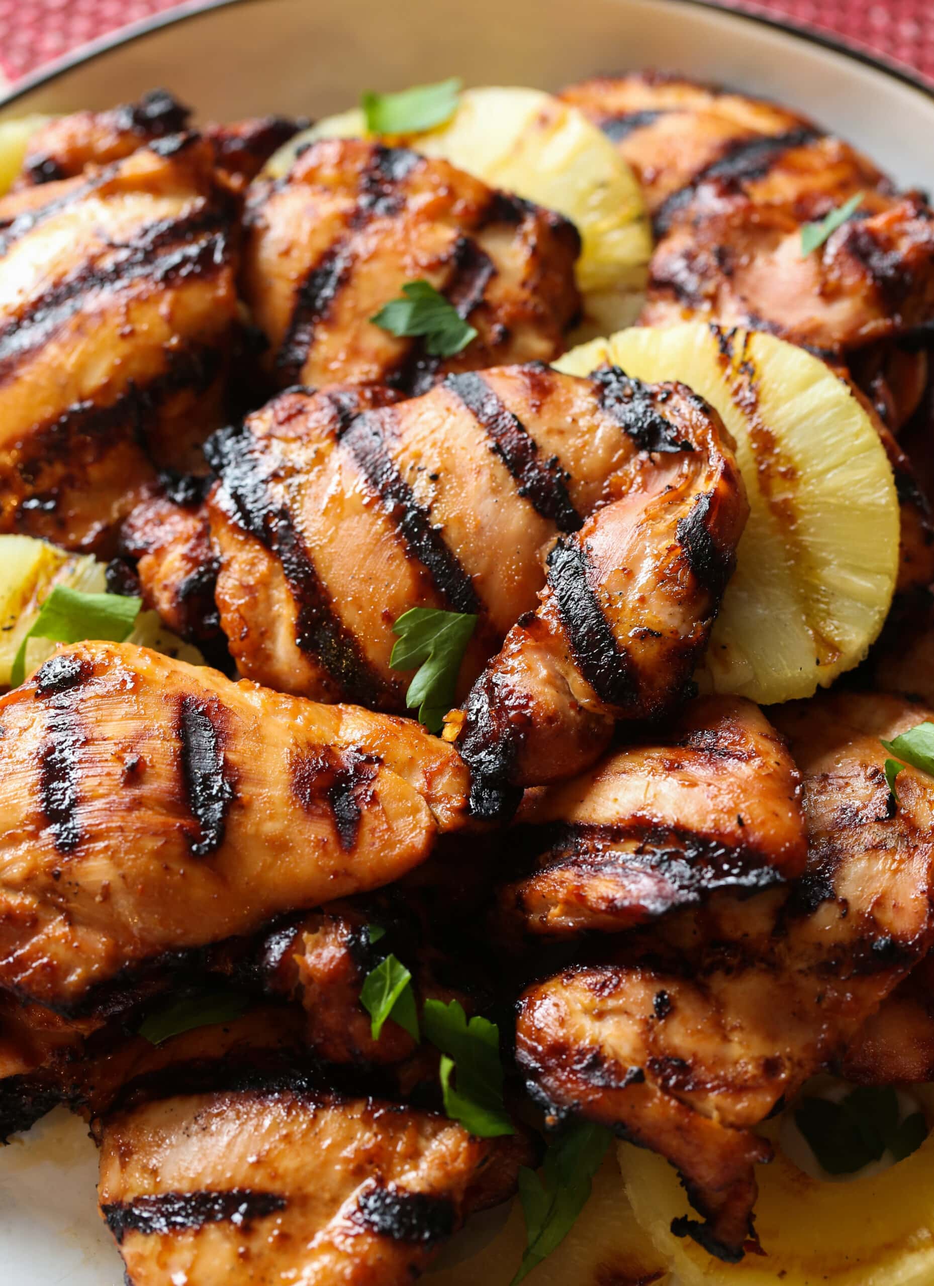 Hawaiian grilled huli huli chicken thighs with pineapple on a plate.