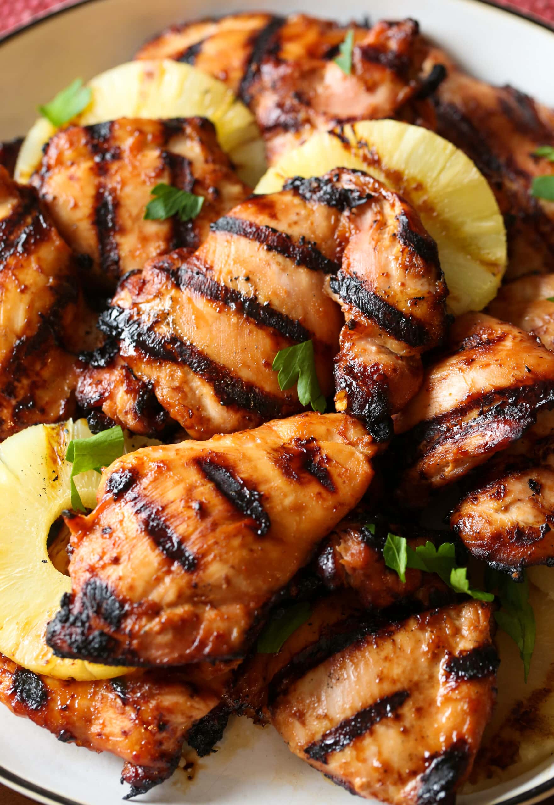 Hawaiian grilled huli huli chicken thighs with pineapple on a plate.