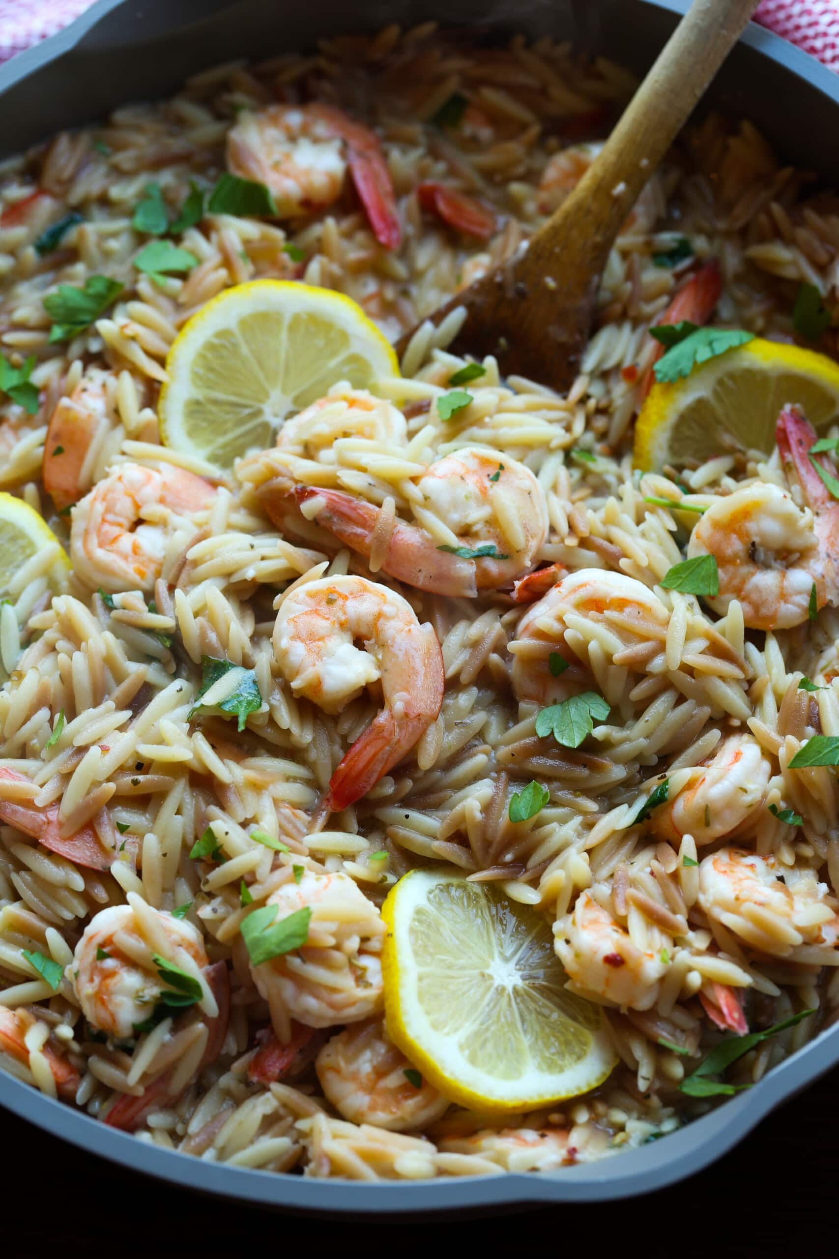 Shrimp orzo in a skillet with lemons.