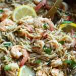 Shrimp orzo in a skillet with lemons.