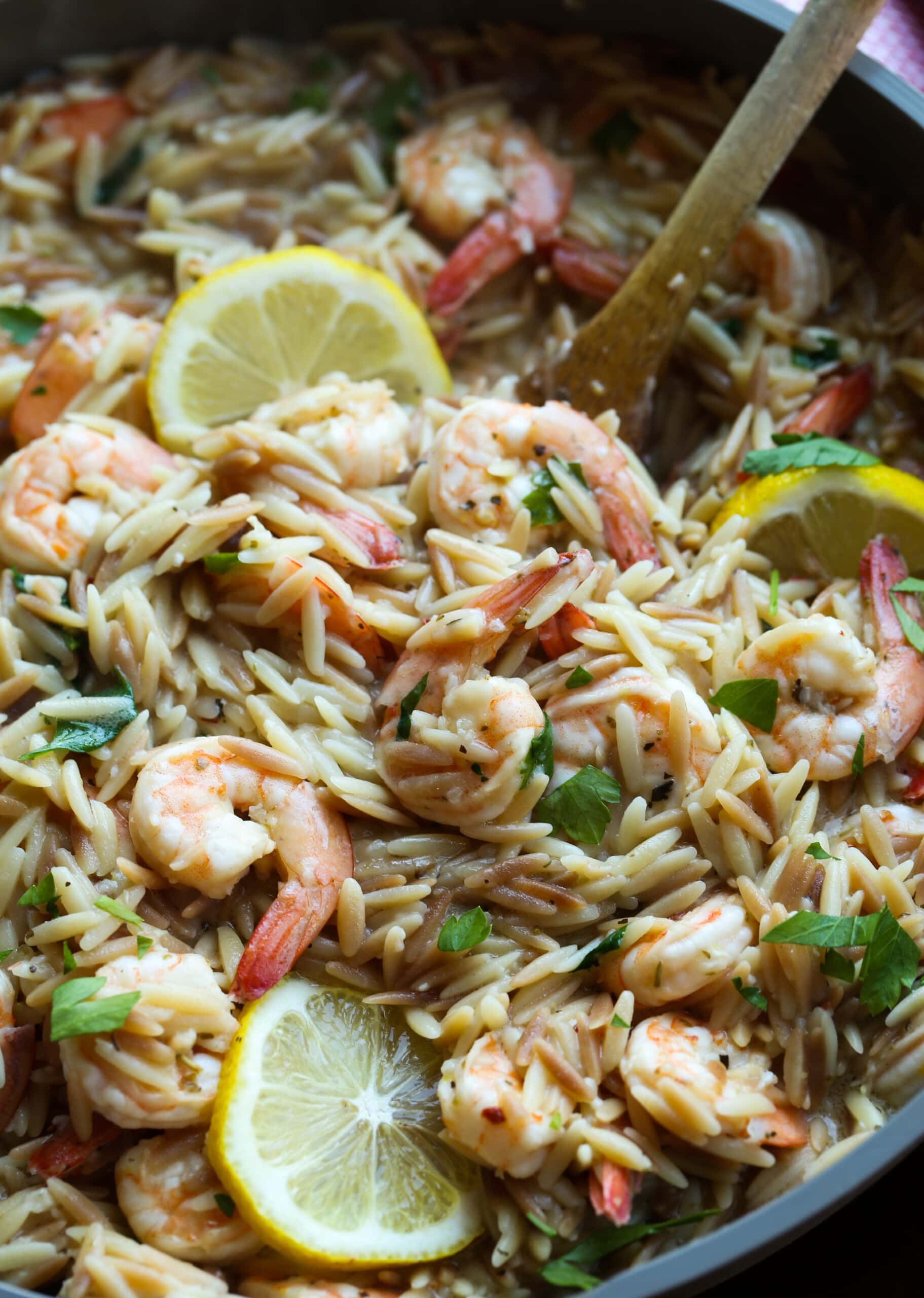 Shrimp orzo in a skillet with lemons.