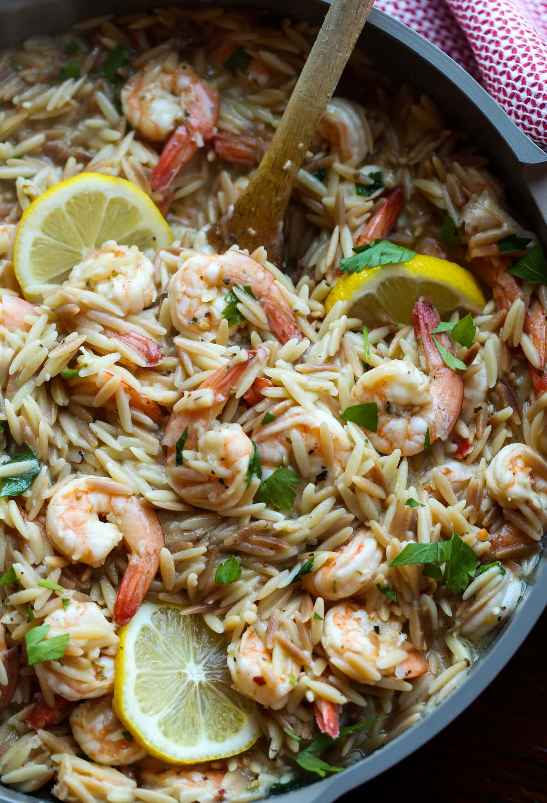 Shrimp orzo in a skillet with lemons.