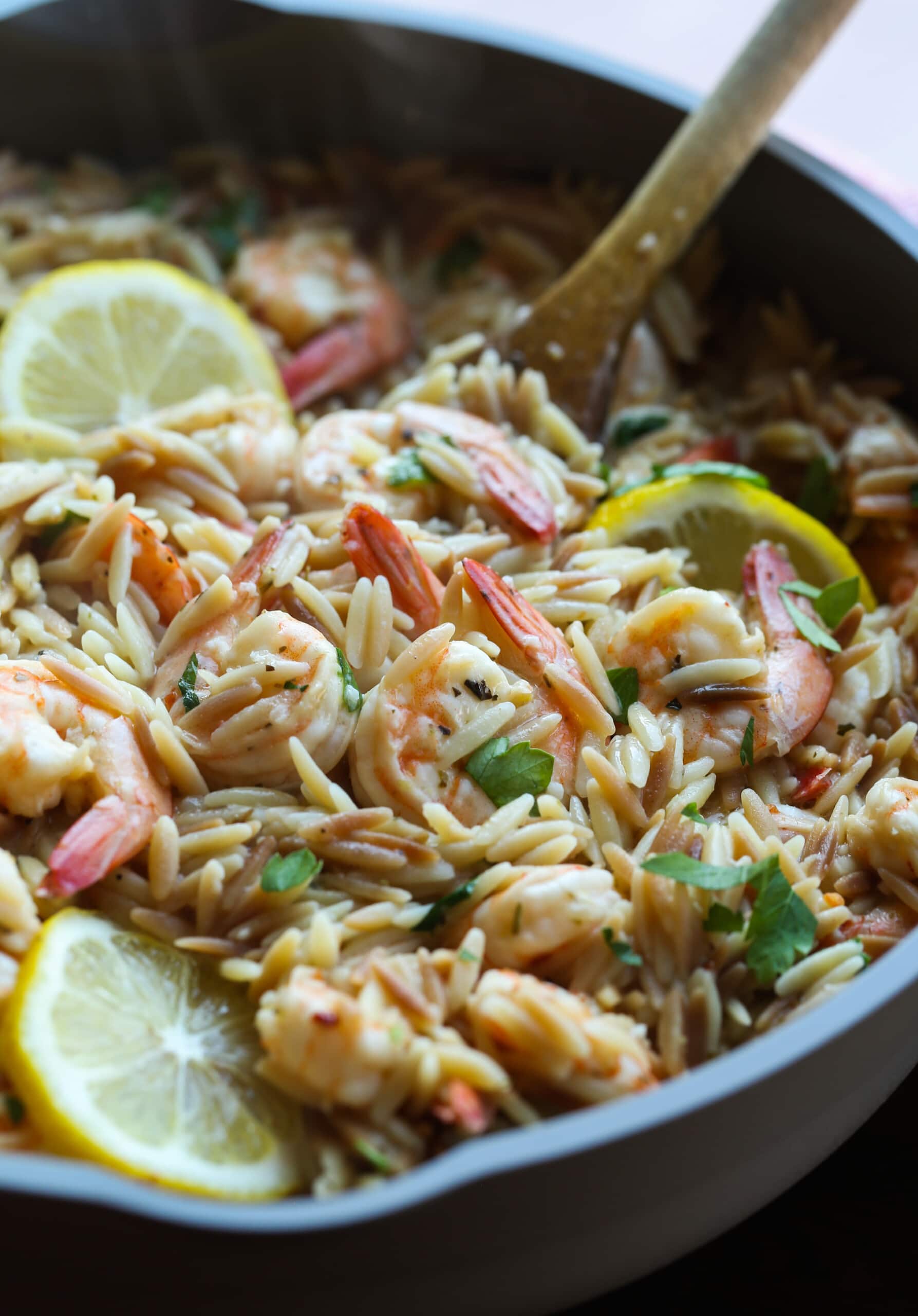 Shrimp orzo in a skillet with lemons.