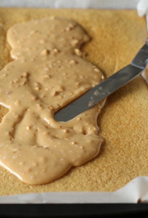 Peanut butter cake batter is spread evenly in a jelly roll pan.