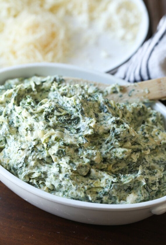 The ingredients for spinach and artichoke dip are combined in a baking dish.