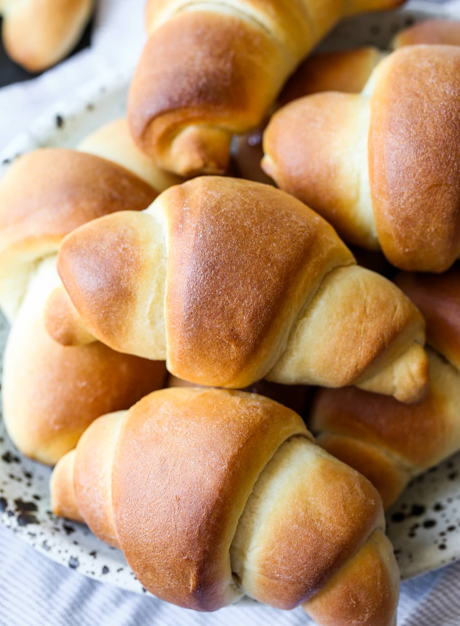 An assortment of golden baked crescent rolls.