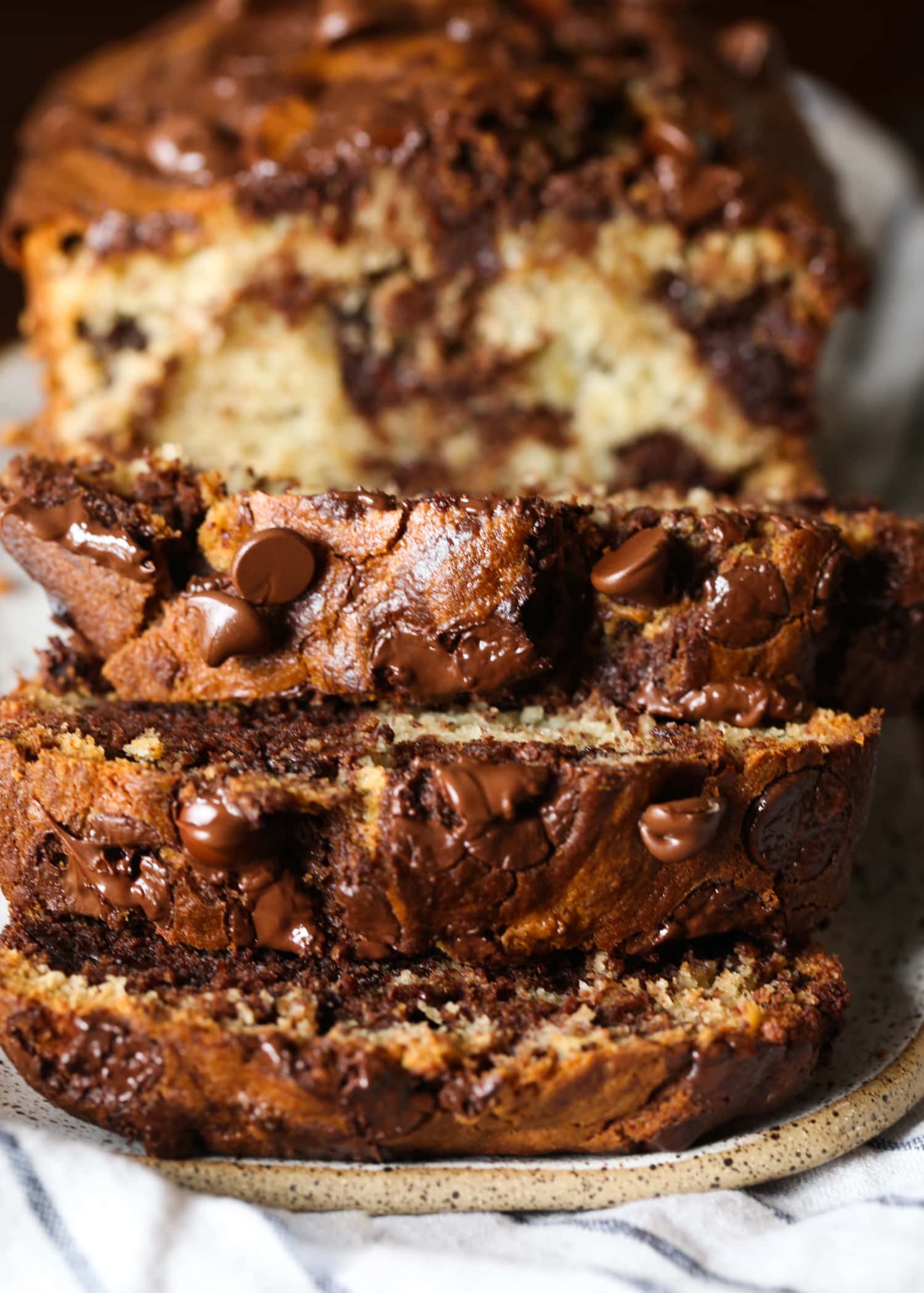 A loaf of chocolate marbled banana bread sliced to reveal the marbled interior.