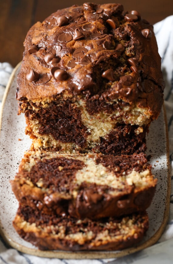 A loaf of chocolate marbled banana bread sliced to reveal the marbled interior.