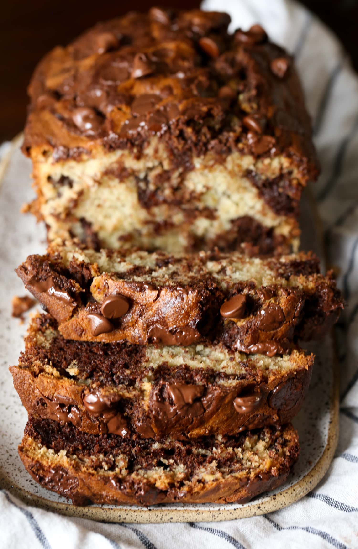 A loaf of chocolate marbled banana bread sliced to reveal the marbled interior.