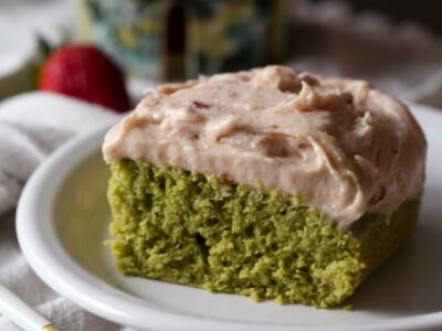 slice of matcha cake with strawberry frosting