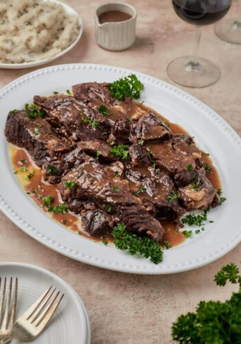 Juicy Instant Pot short ribs on a white platter.