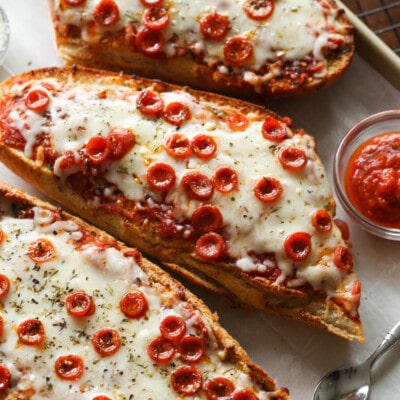 Three French bread pizzas on a platter.