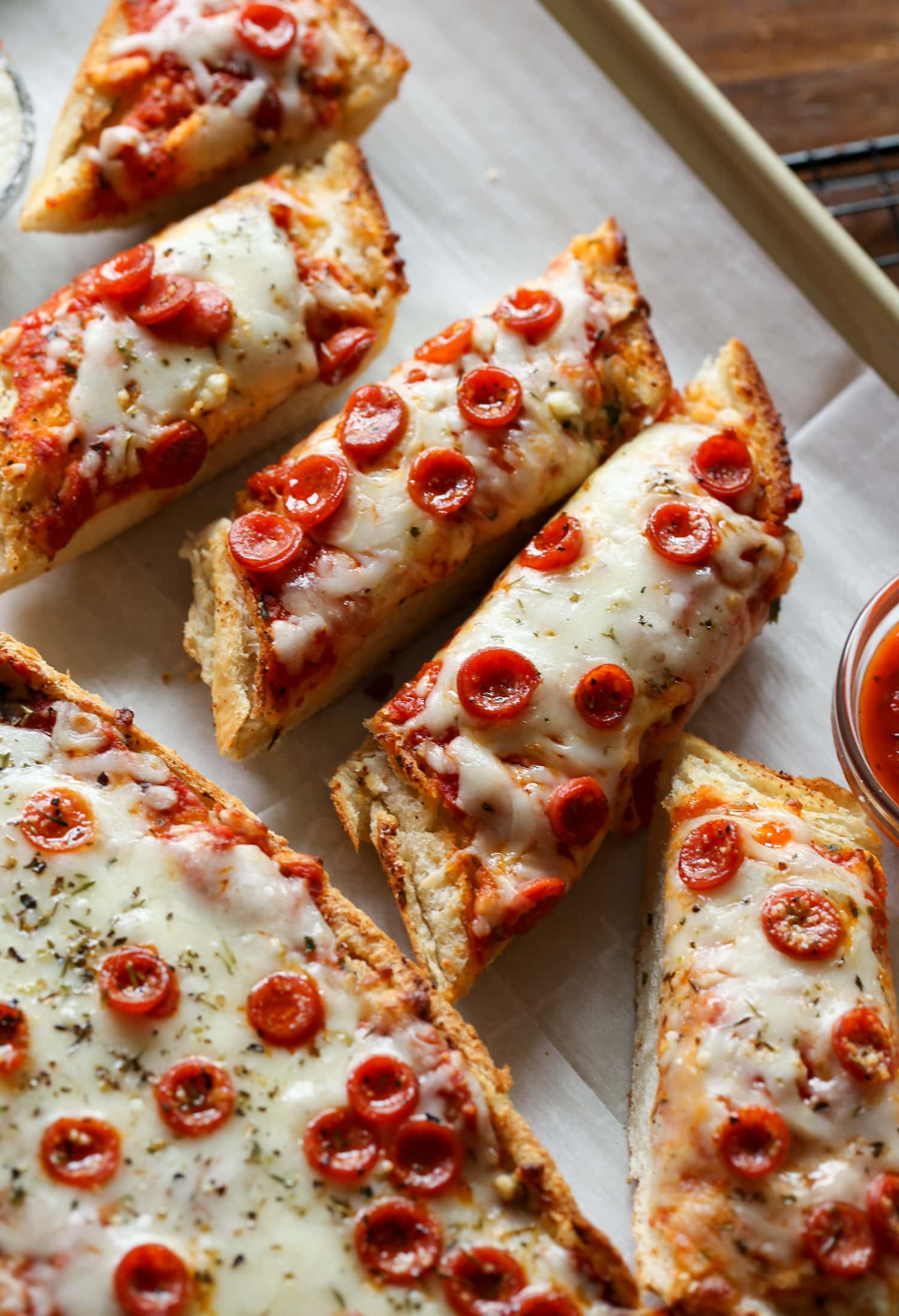 French bread pizza cut into individual slices on a platter.