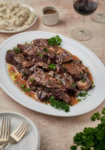 Juicy Instant Pot short ribs on a white platter.
