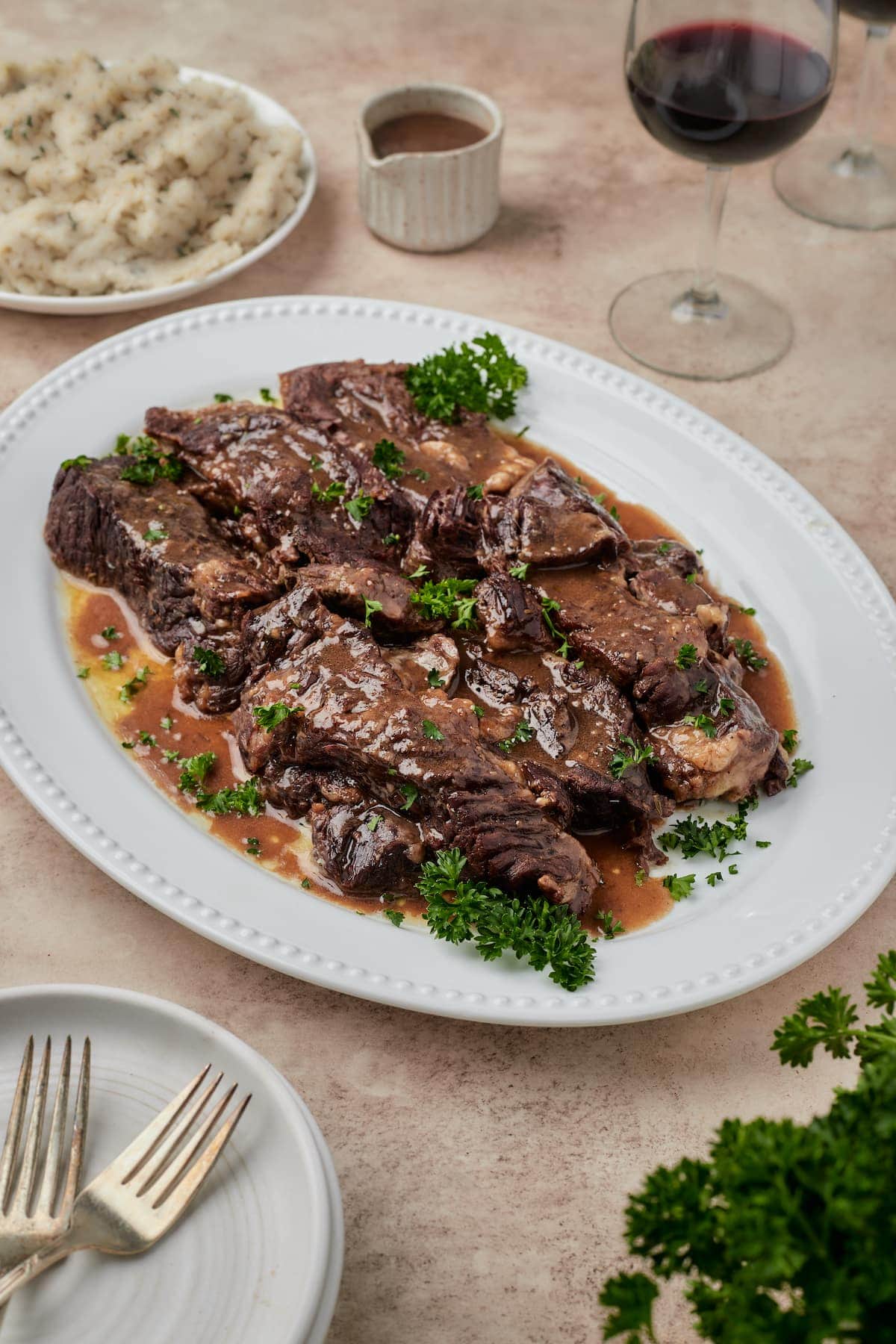 Juicy Instant Pot short ribs on a white platter.