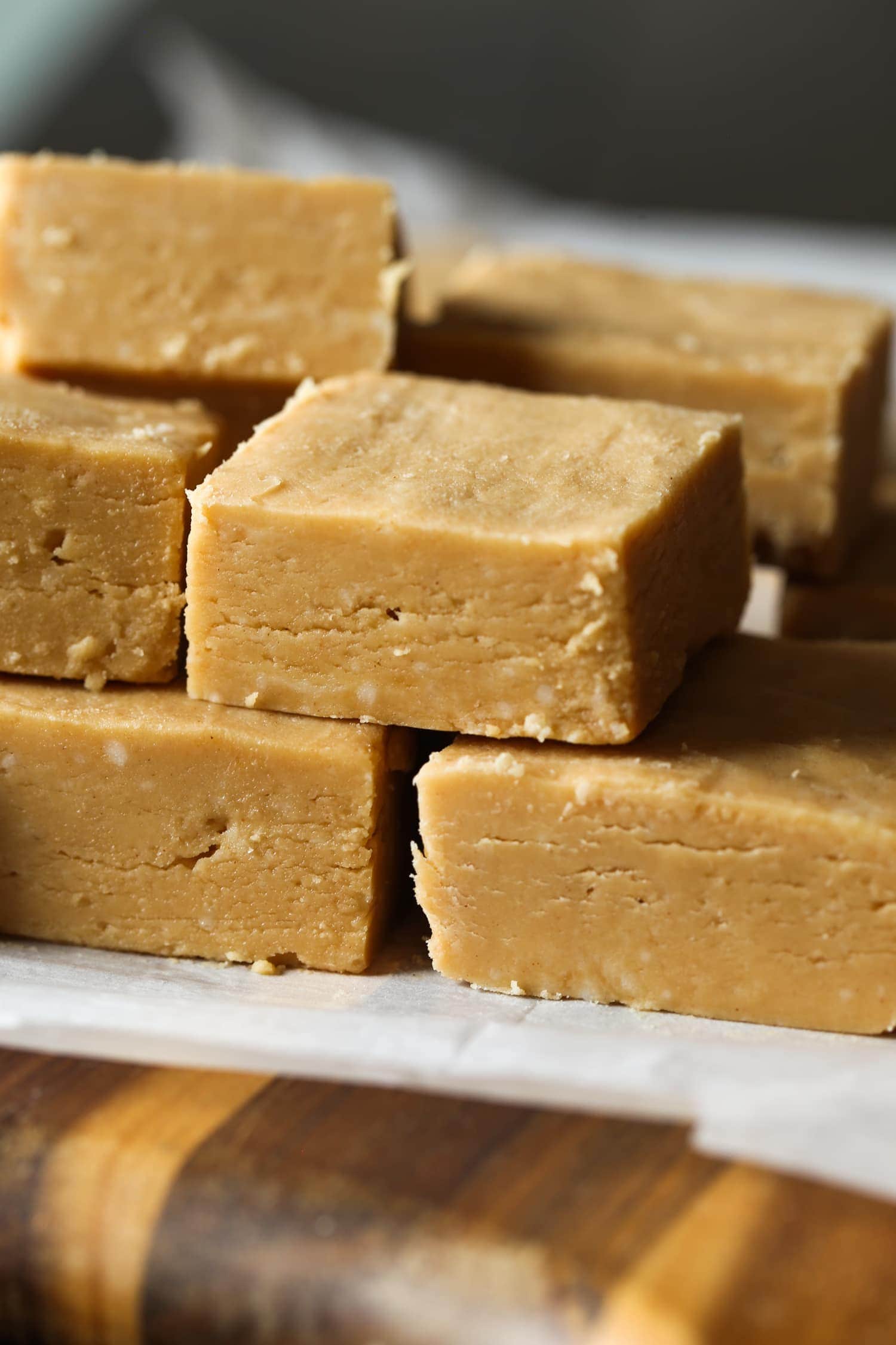 Stack of peanut butter fudge squares on parchment paper.