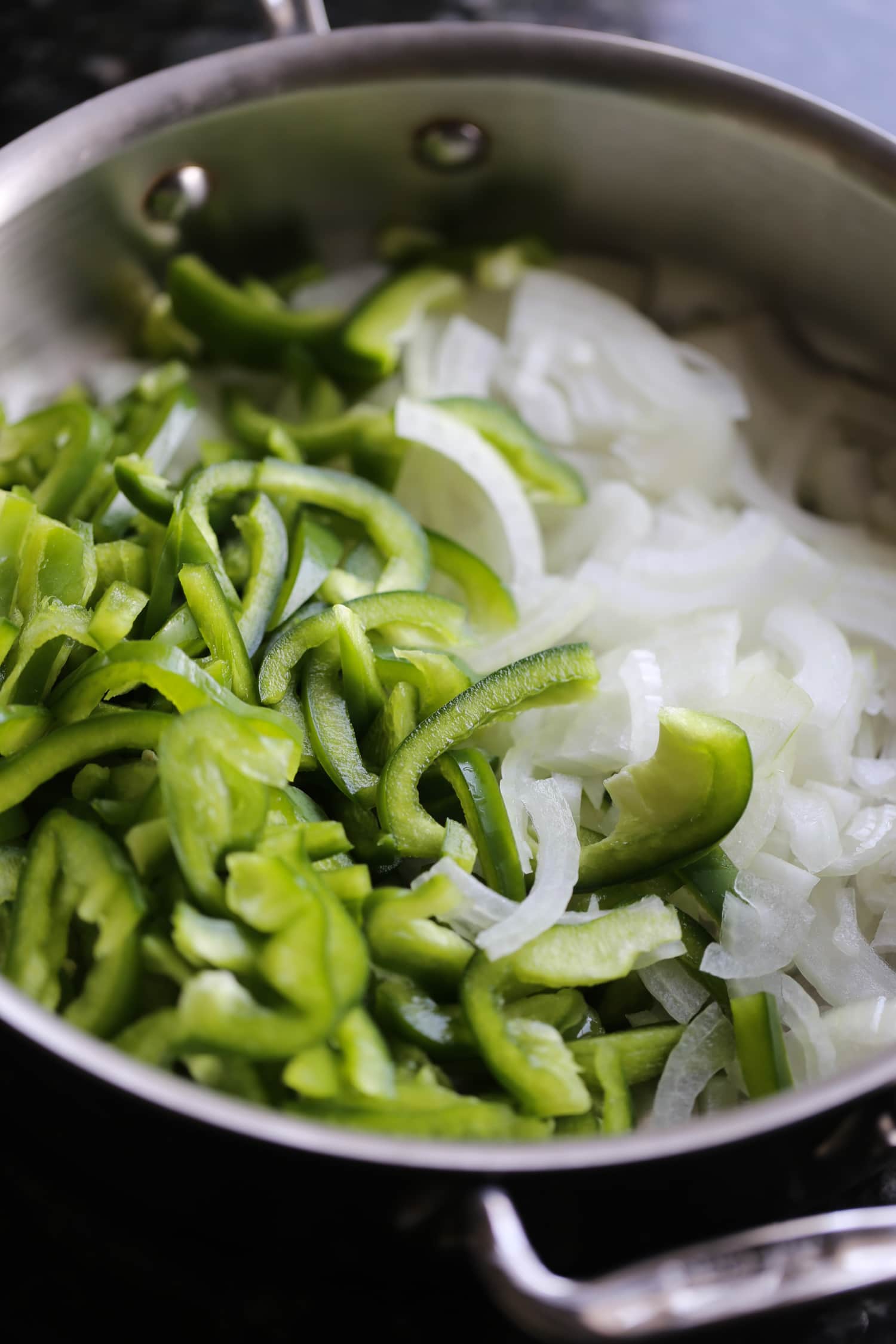 Green peppers and onions in a large pot.