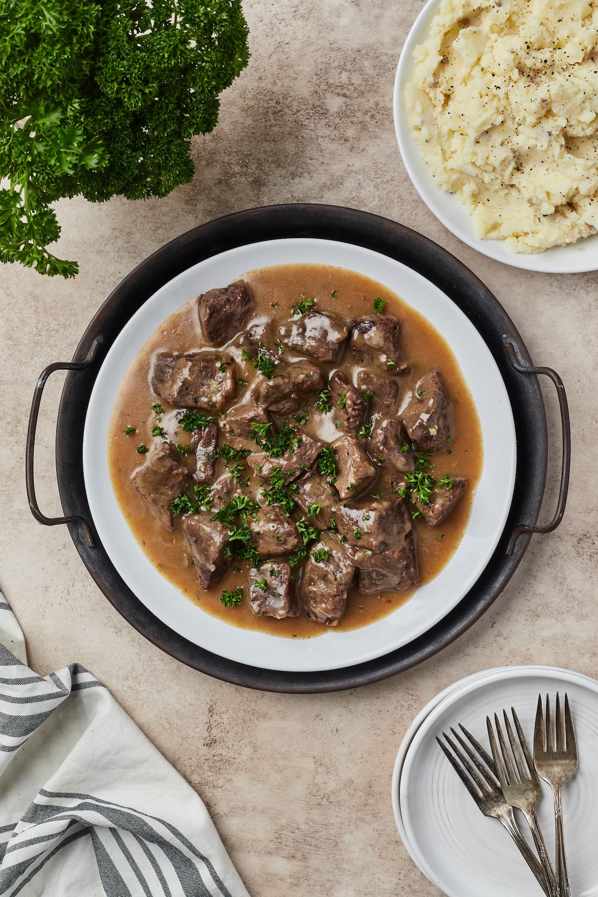 Top view of cubed beef covered with gravy on a round serving dish.