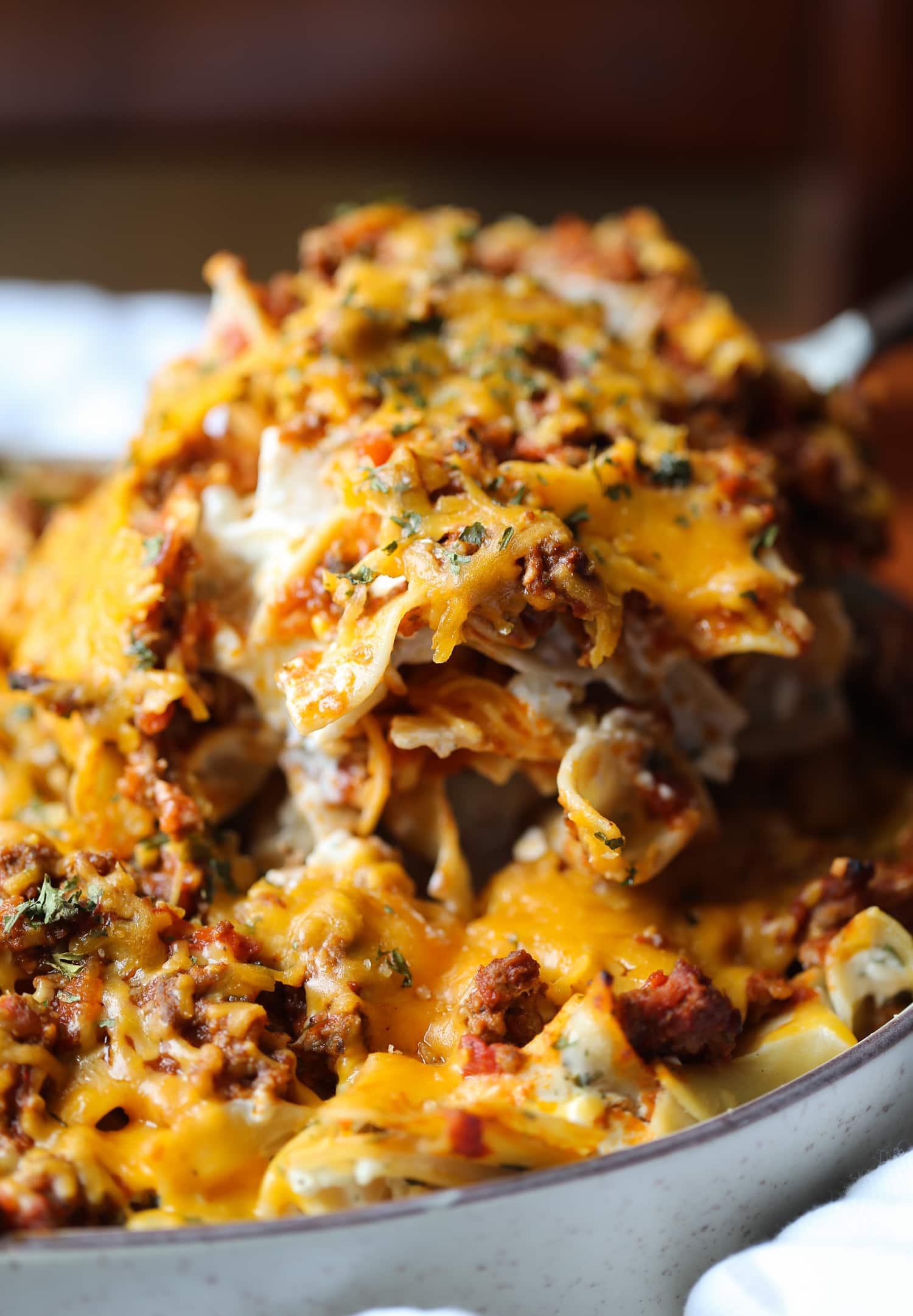 A scoop of fried noodles is lifted from the casserole dish.