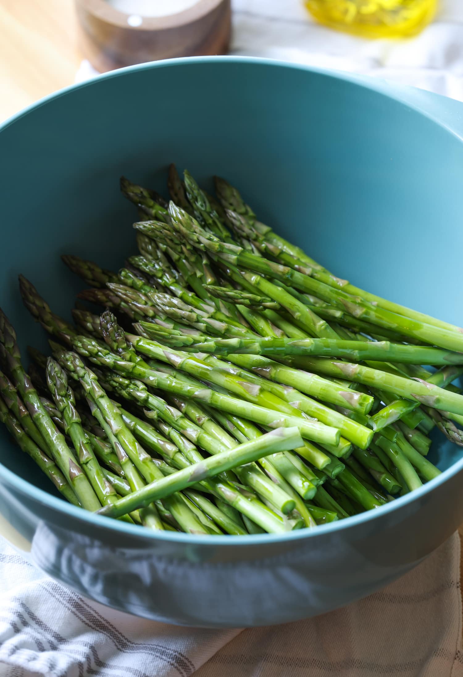 Asparagus spears in a large blue bowl.