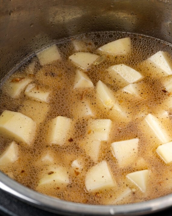 Potatoes and broth simmering in the Instant Pot.