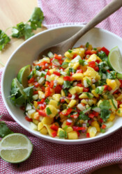 Fresh salsa made with mango in a bowl with a spoon