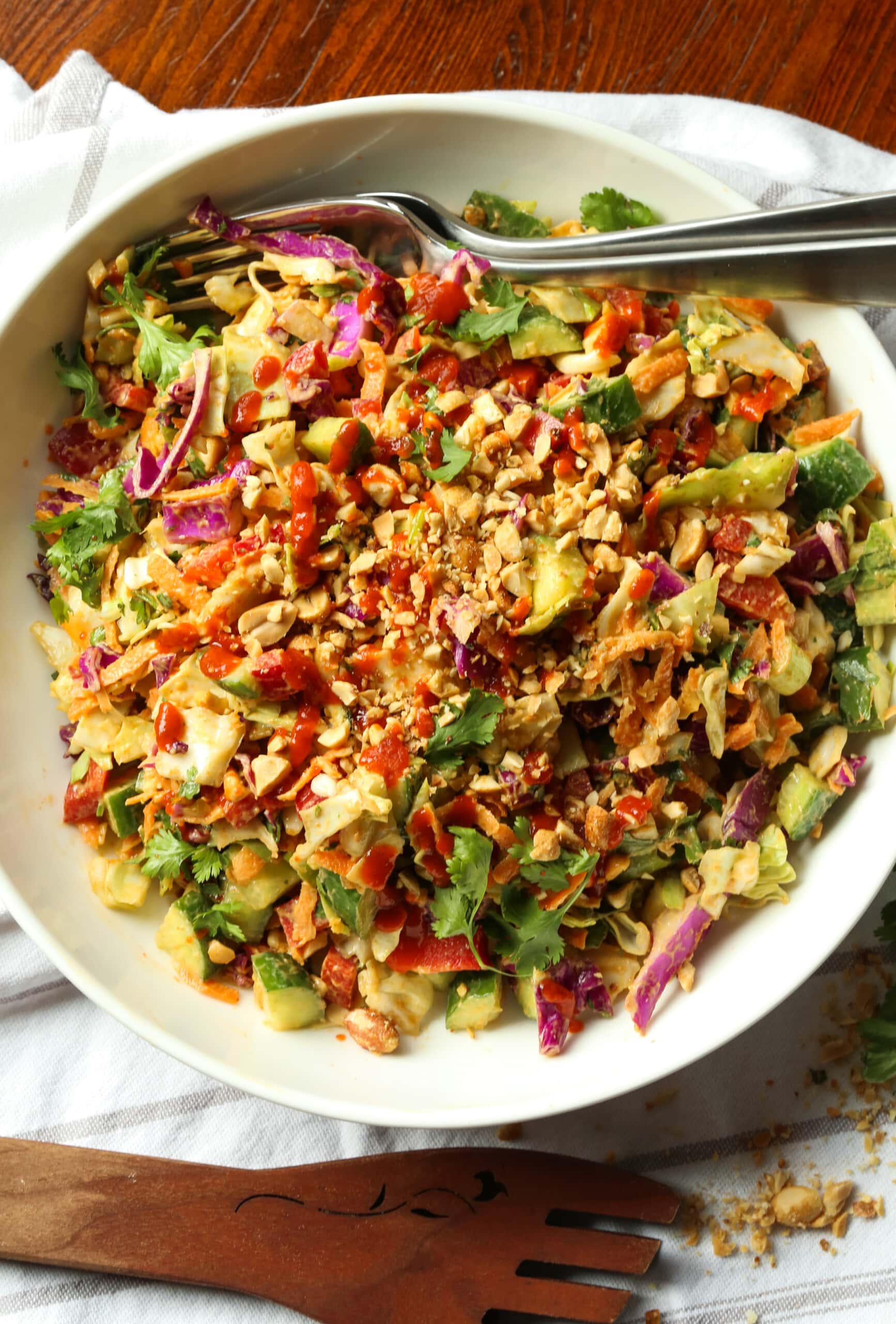 Rainbow crunch salad in a large white bowl, with a fork.