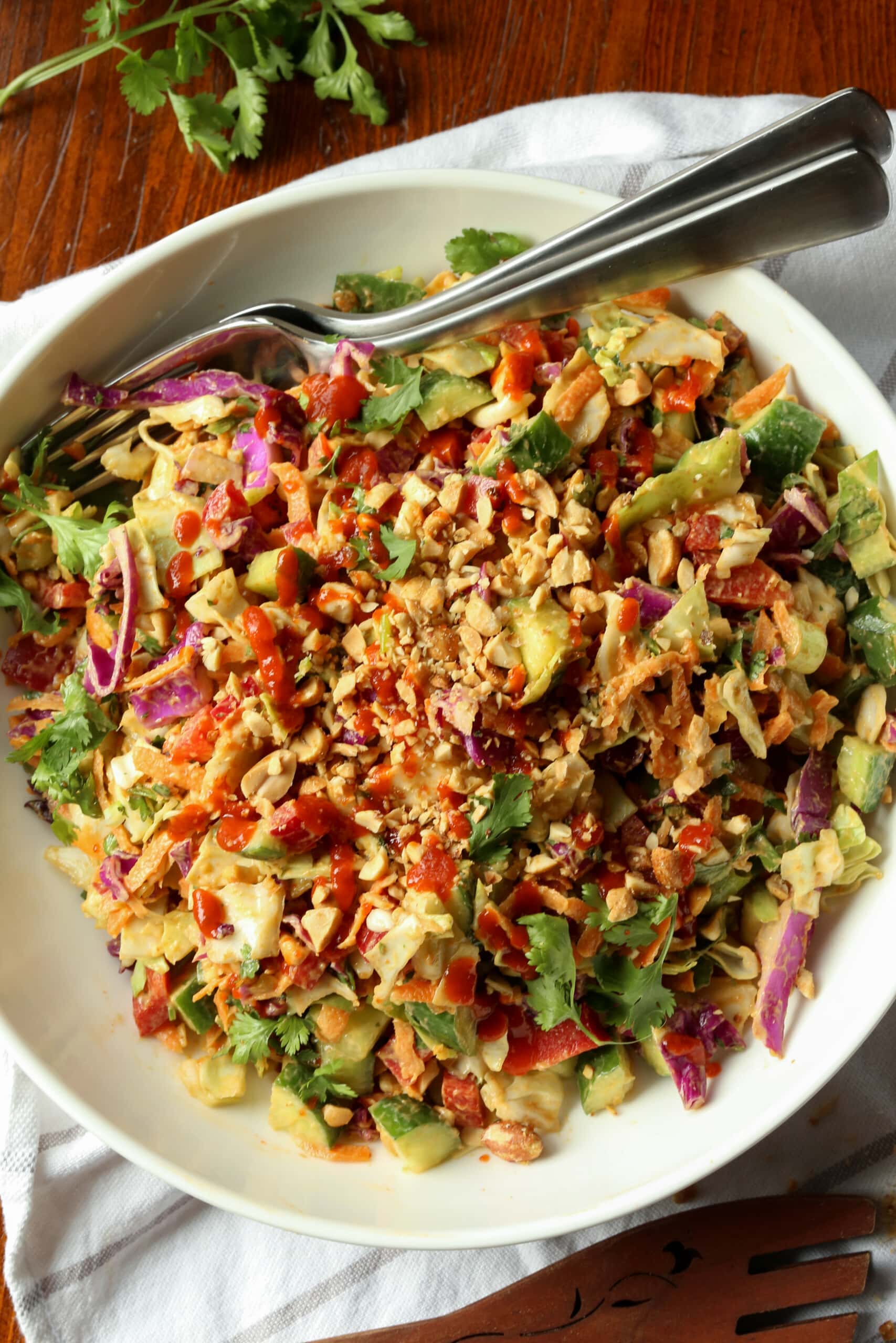 Rainbow crunch salad in a large white bowl, with a fork.