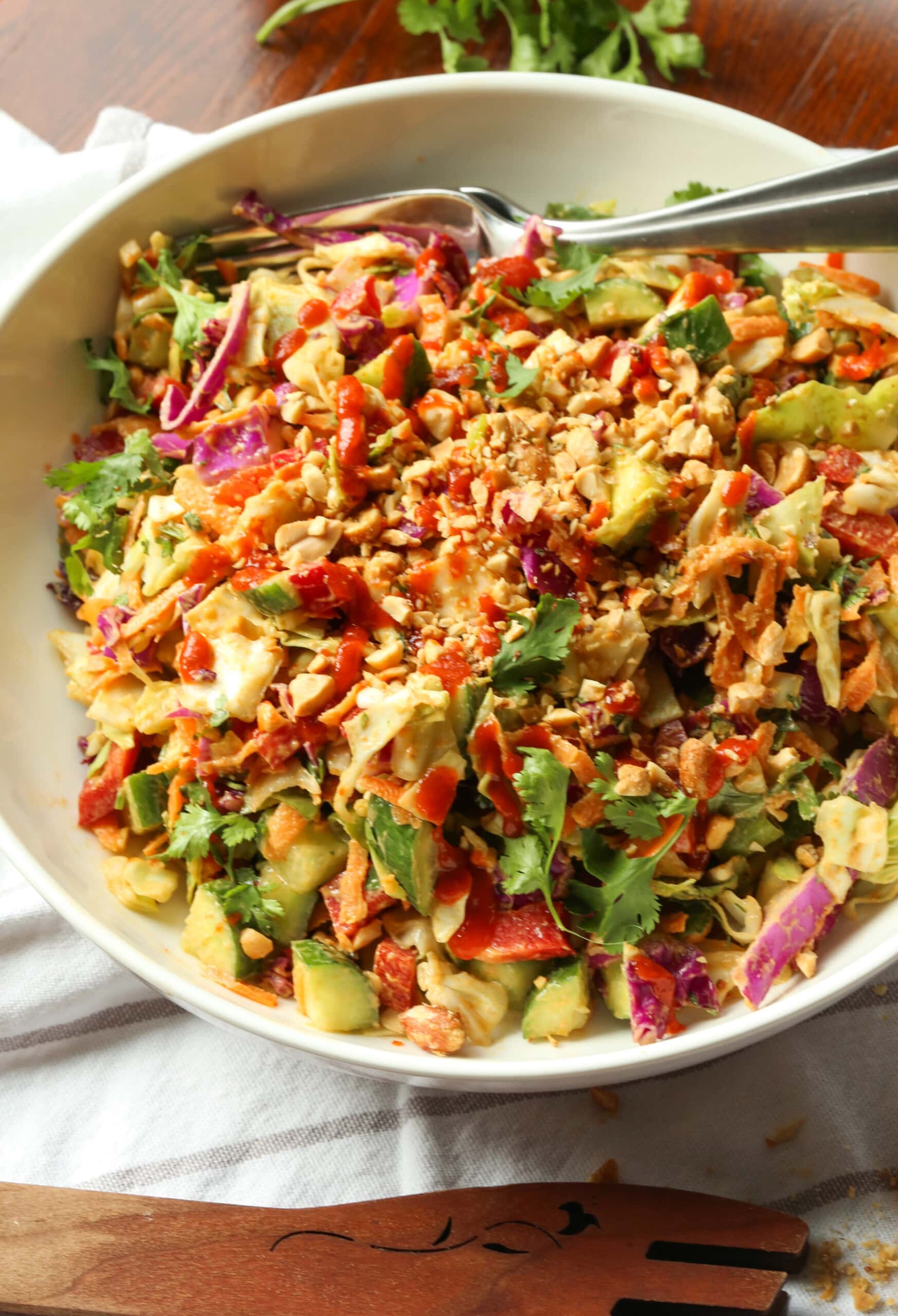Regenbogen-Crunch-Salat in einer großen weißen Schüssel mit einer Gabel.