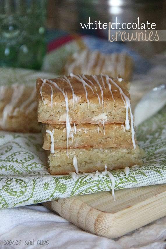 Three white chocolate brownies stacked on a green and white napkin