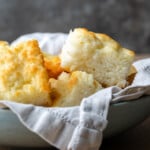 Butter swim biscuits in a serving bowl lined with a cloth.