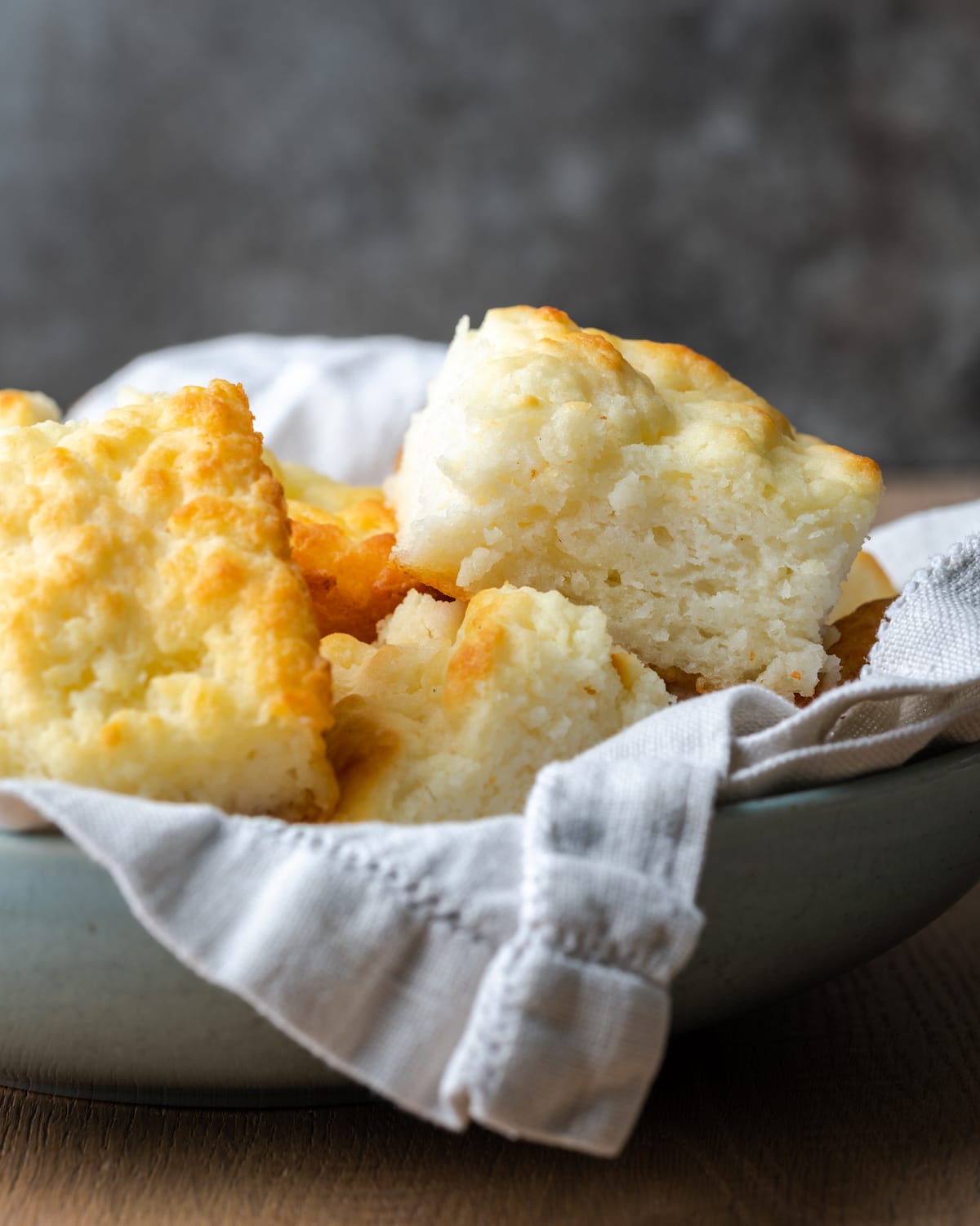 Butter swim biscuits in a serving bowl lined with a cloth.
